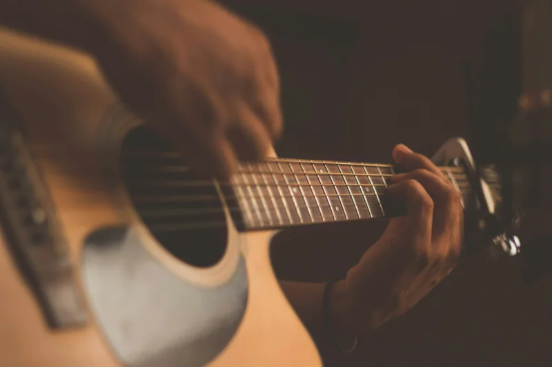 Close-up of guitar strings and warm wooden body